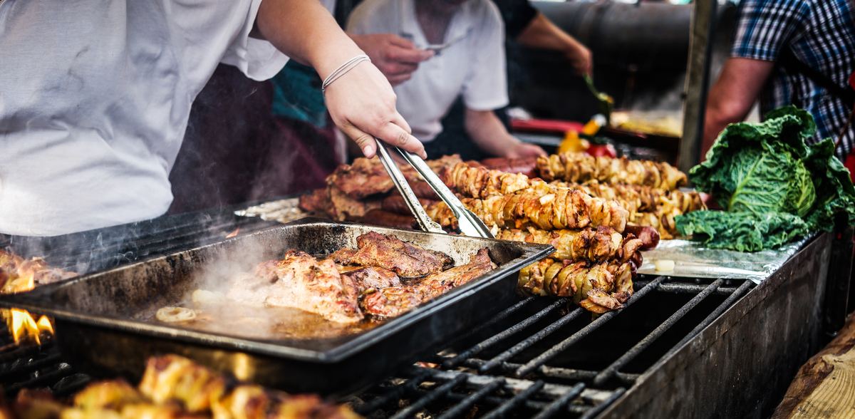 Sissende vleesspiezen en gegrild vlees op een houtskoolgrill